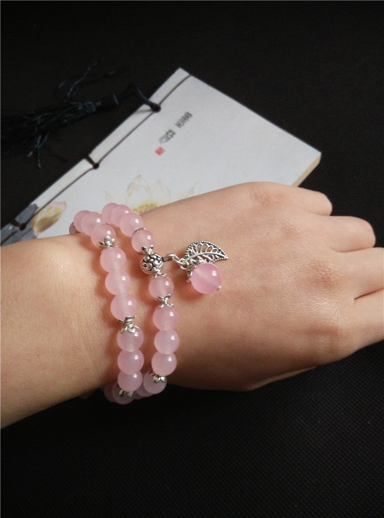 Pink Chalcedony beaded double-wrap bracelet with silver charms on wrist