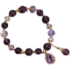 Amethyst beaded bracelet with pear-shaped cubic zirconia pendant on white background