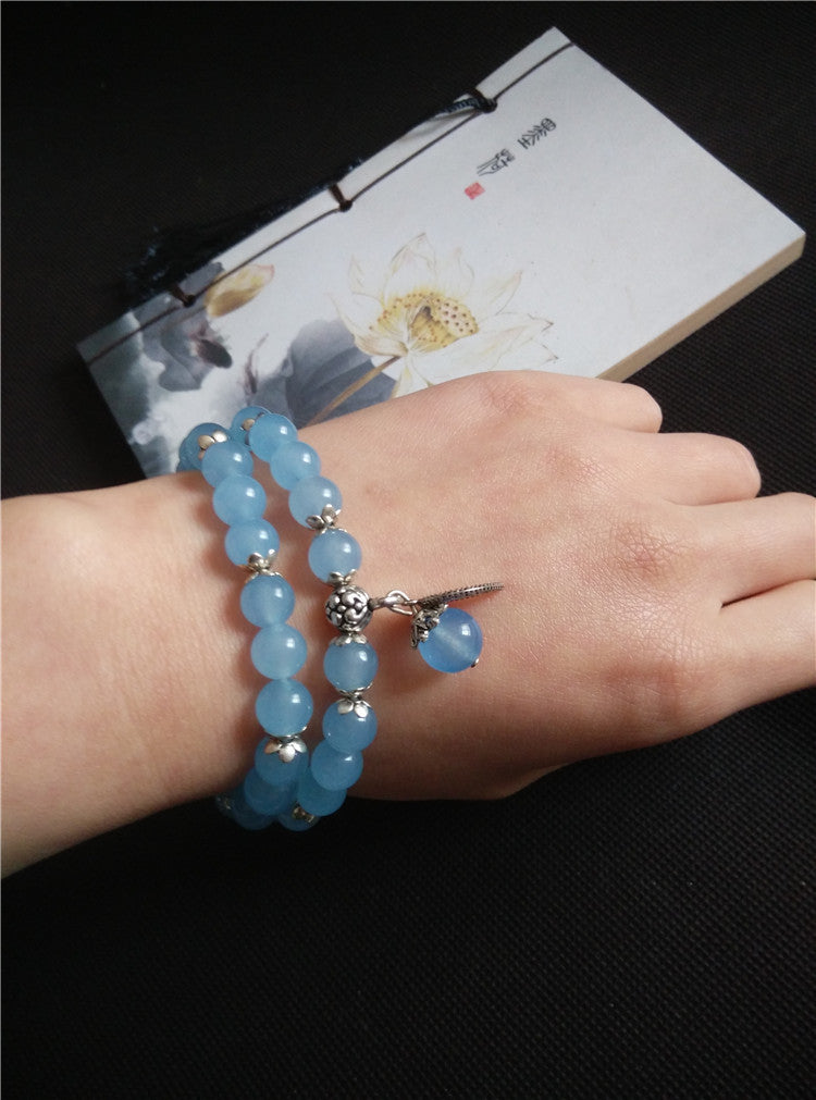Blue Chalcedony beaded double-wrap bracelet with silver charms on wrist