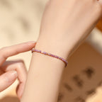 Woman wearing delicate purple beaded bracelet with gold heart on wrist