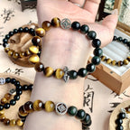 Tiger's Eye and Obsidian bracelet on a wrist with silver charm detail
