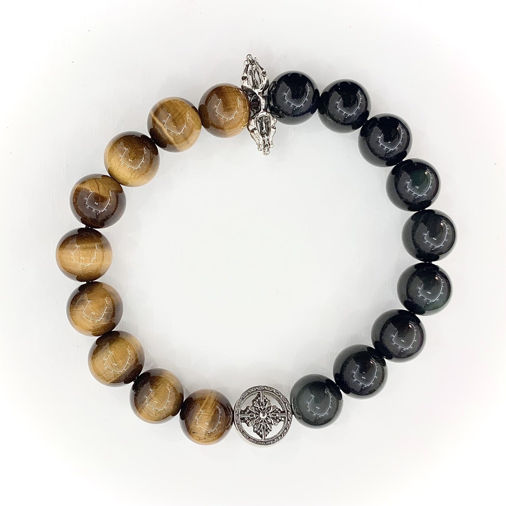Tiger's Eye and Obsidian bracelet on a wrist with silver charm detail