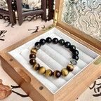 Tiger's Eye and Obsidian beaded bracelet with silver charm in a wooden box